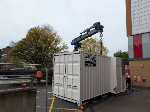 Containerised UPS being delivered by crane to a hospital data centre.