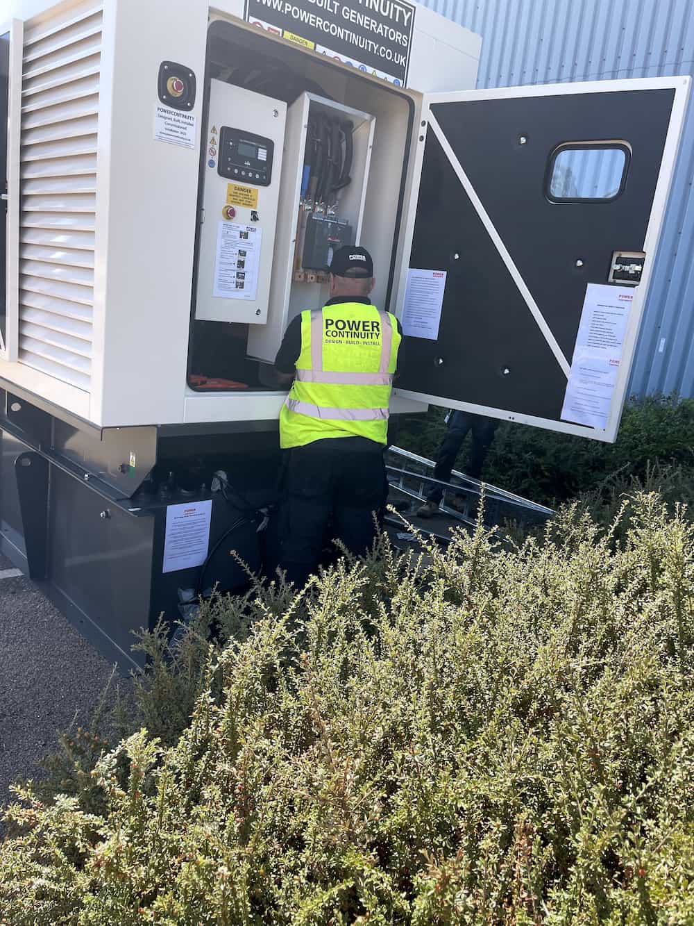 Power continuity engineer checking canopied generator