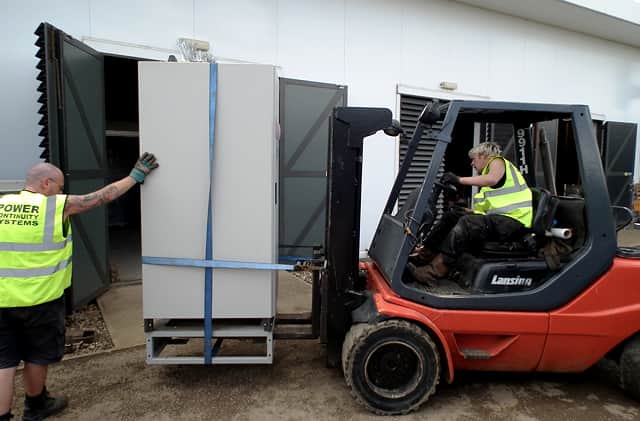 Power continuity engineers removing a ups