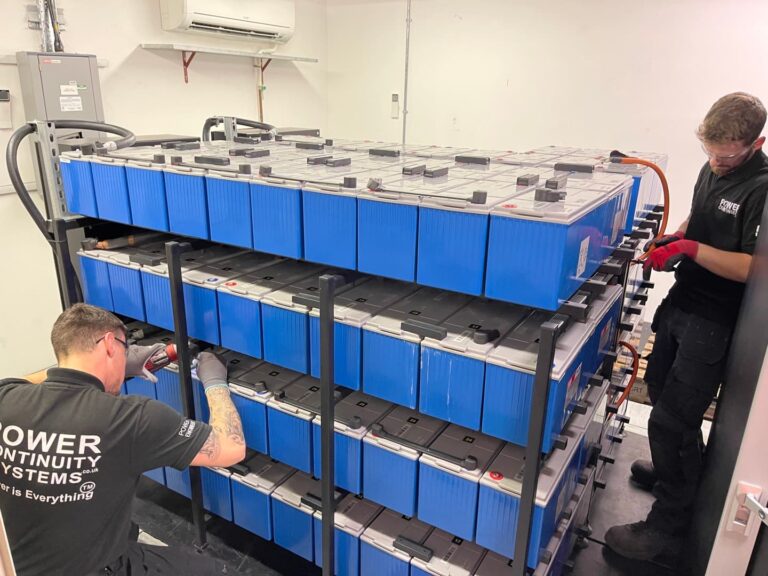 Power continuity engineers setting up a battery rack for a ups