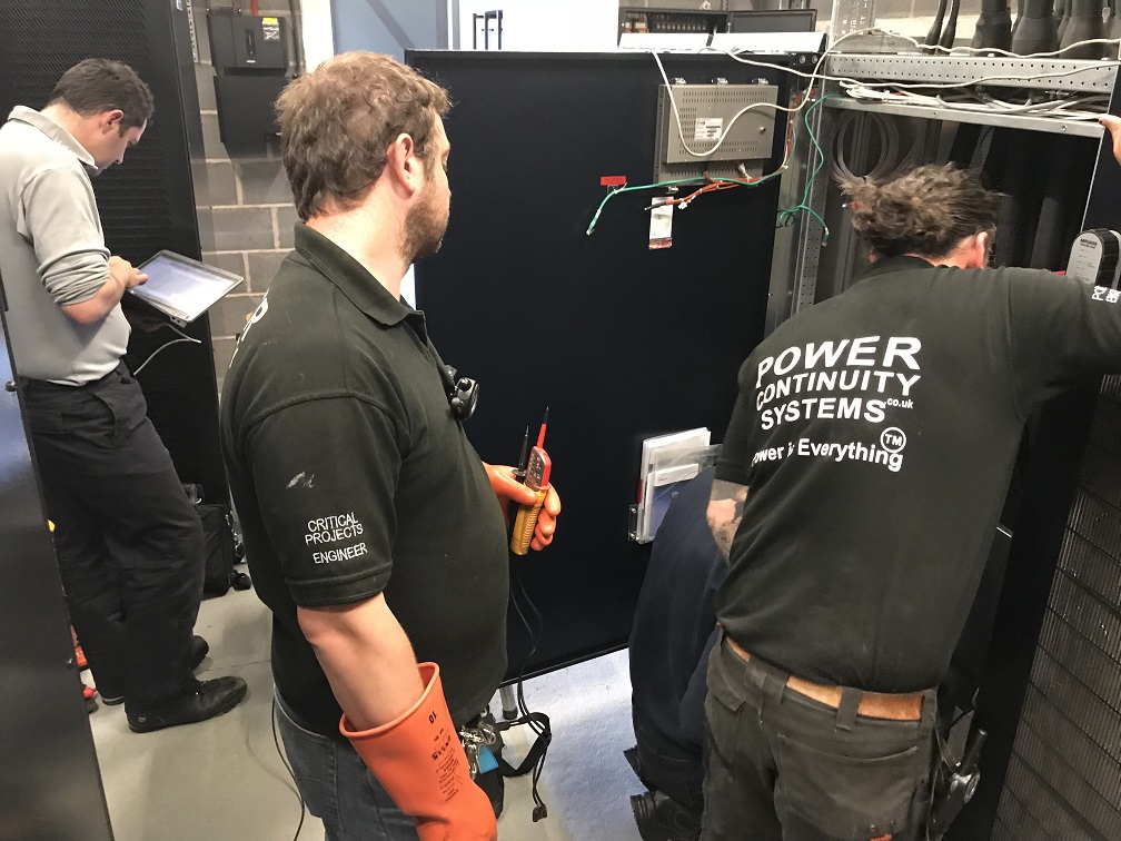 Power continuity engineers working on a ups