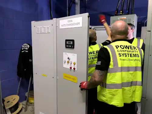 Power continuity engineers working on automatic change over panel