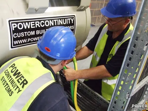 Power continuity engineers working on generator